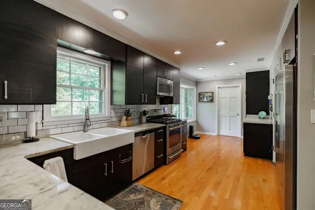 a large kitchen with stainless steel appliances kitchen island granite countertop a sink and cabinets