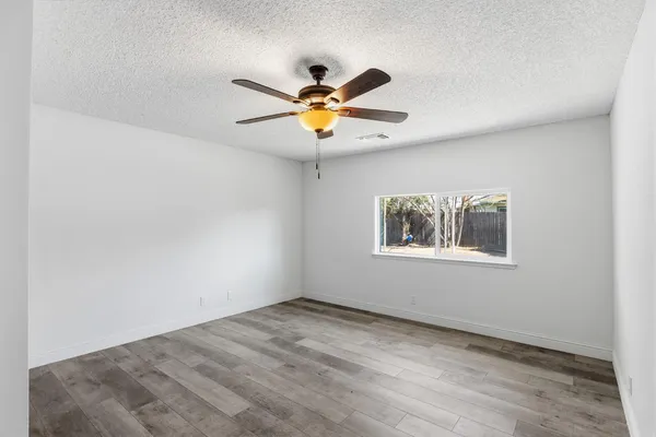 a view of empty room with wooden floor