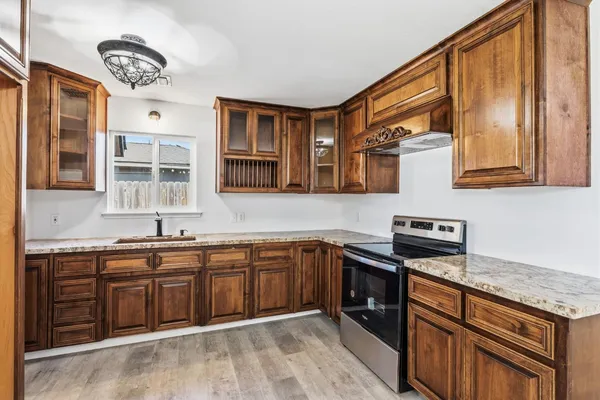 a large kitchen with stainless steel appliances granite countertop a refrigerator and a stove top oven