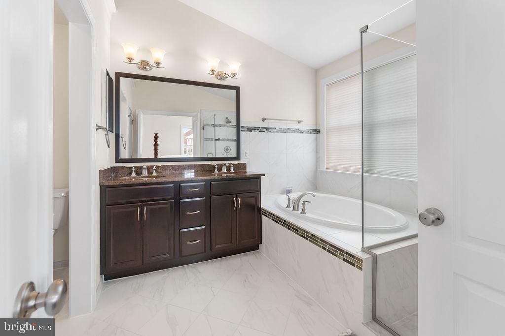 7608 Elmcrest Road Hanover, MD 21076 - Photo 21 of 41 a spacious bathroom with a tub sink and mirror