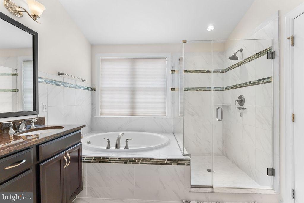 7608 Elmcrest Road Hanover, MD 21076 - Photo 23 of 41 a bathroom with a granite countertop sink a mirror and a bathtub