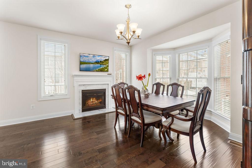 7608 Elmcrest Road Hanover, MD 21076 - Photo 5 of 41 a dining room with furniture a chandelier and wooden floor