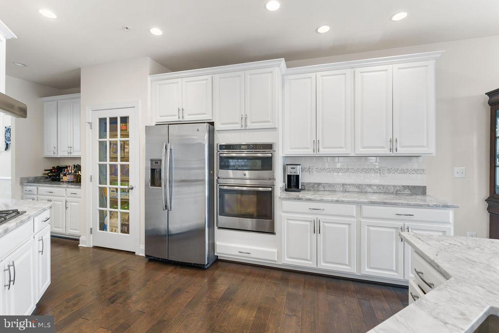 7608 Elmcrest Road Hanover, MD 21076 - Photo 8 of 41 a kitchen with stainless steel appliances white cabinets and a refrigerator