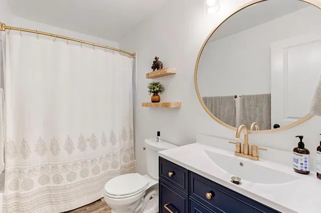 a bathroom with a sink a toilet and a mirror