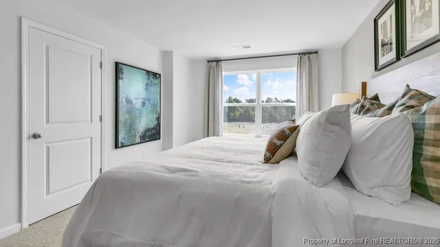 a large bed sitting in a bedroom next to a window