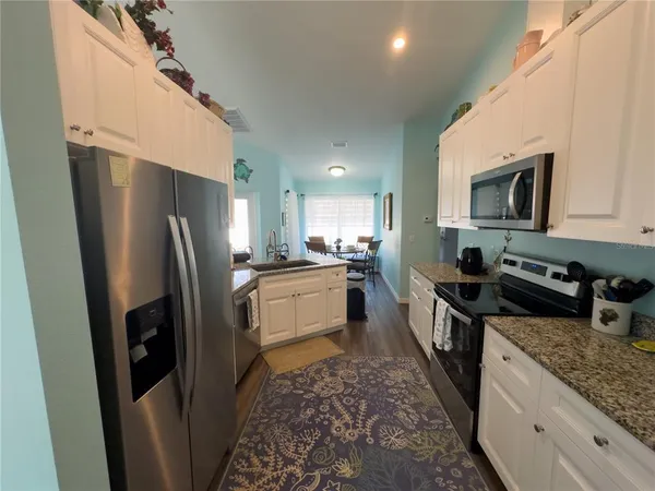 a kitchen with stainless steel appliances granite countertop a refrigerator stove microwave and sink