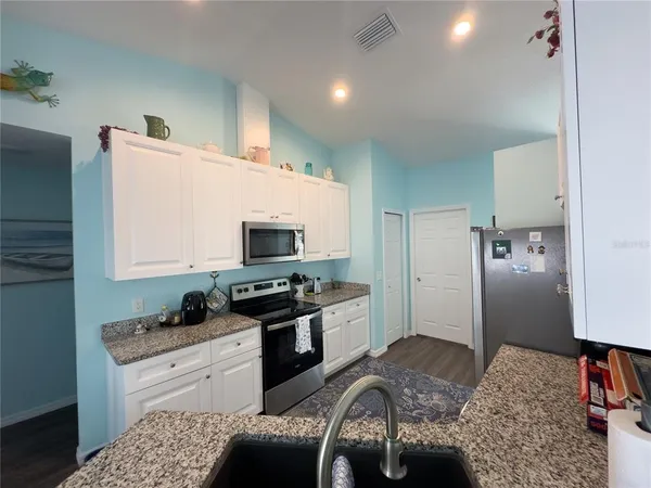 a kitchen with a stove a sink and a refrigerator