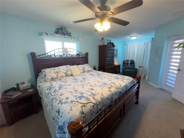 a bed sitting in a room next to a window and a chandelier