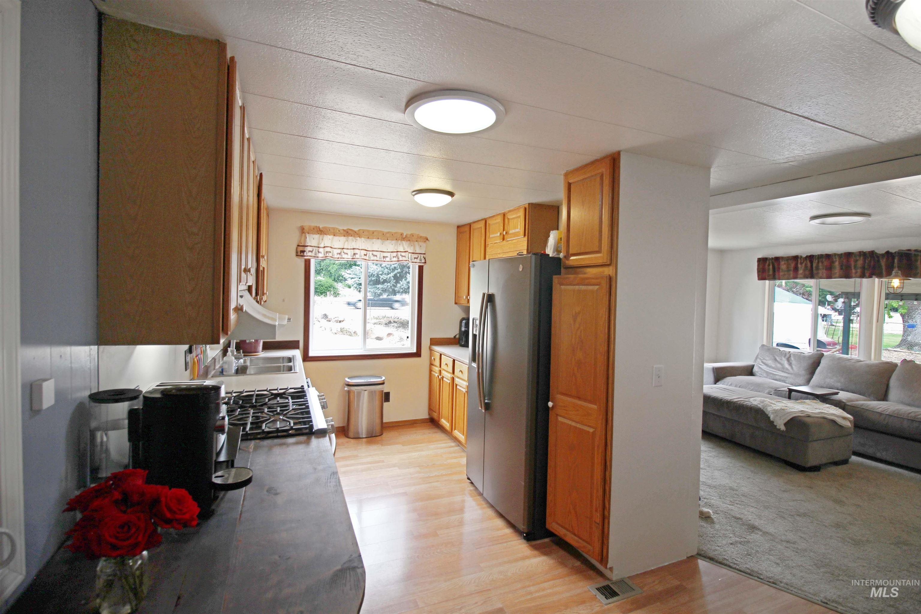 1265 Pioneer Road Weiser, ID 83672 - Photo 11 of 29 Kitchen featuring natural wood-finish cabinetry, stainless steel appliances, and wood-finish flooring