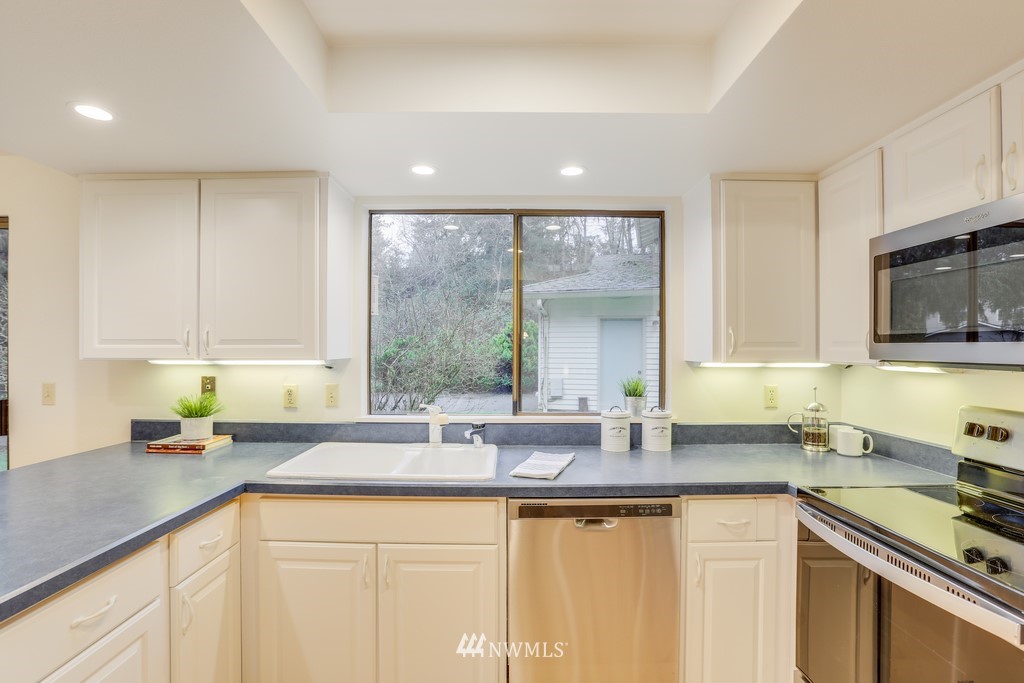 15909 Southeast 178th Street Renton, WA 98058 - Photo 12 of 30 a kitchen with stainless steel appliances granite countertop a sink a stove and cabinets