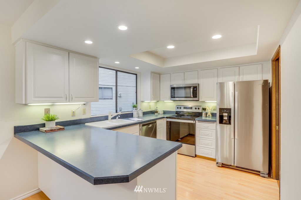 15909 Southeast 178th Street Renton, WA 98058 - Photo 13 of 30 a kitchen with stainless steel appliances granite countertop a sink a stove and refrigerator