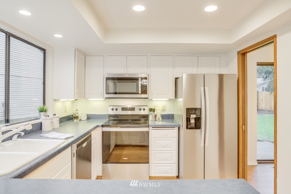 15909 Southeast 178th Street Renton, WA 98058 - Photo 14 of 30 a kitchen with stainless steel appliances granite countertop a refrigerator a stove top oven a sink and dishwasher