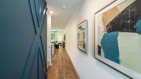 a hallway with a large window and wooden floor