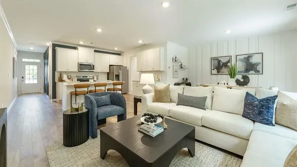 a living room with furniture and a view of kitchen