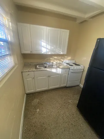 a kitchen with granite countertop a sink and a stove
