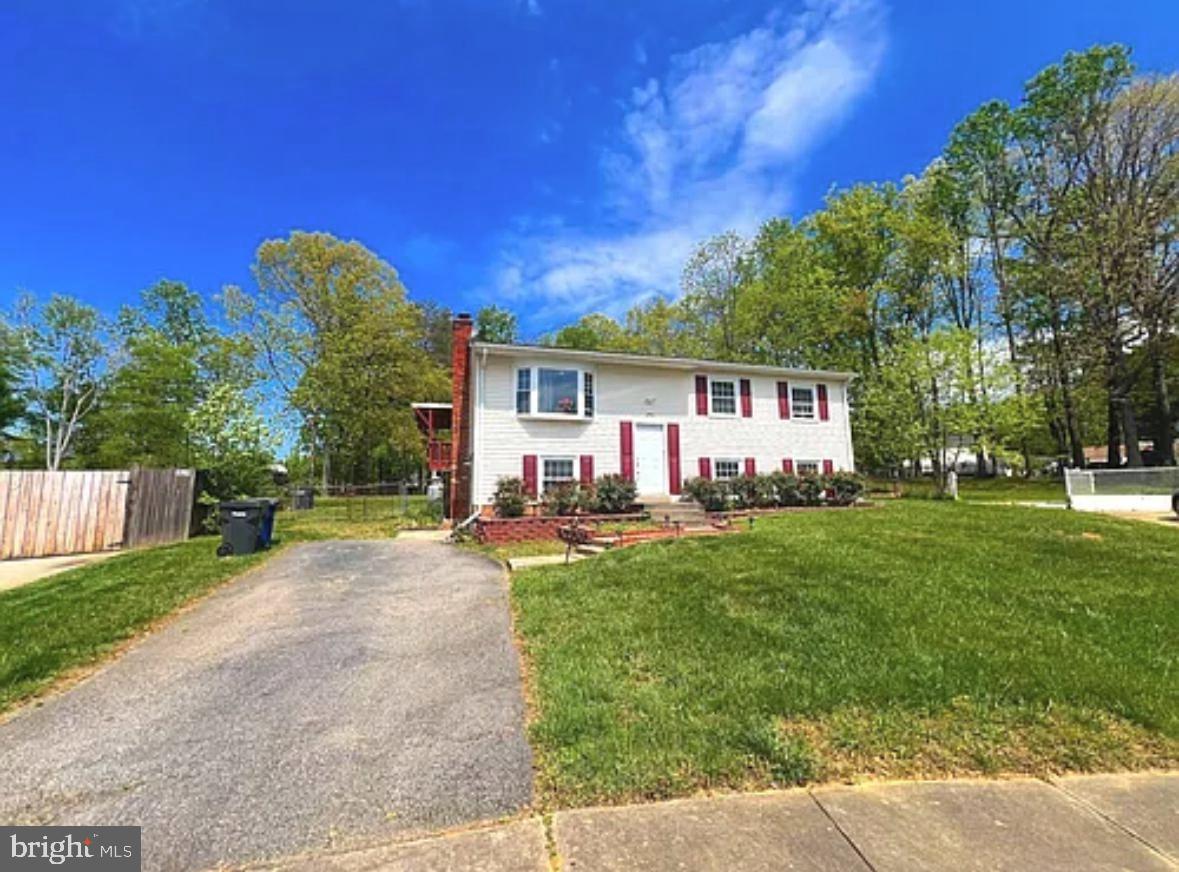 a view of a house with backyard and a tree