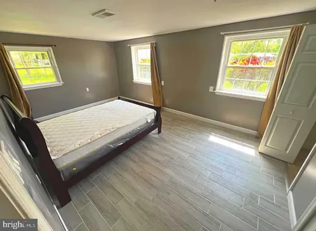 a bed sitting in a bedroom next to a window