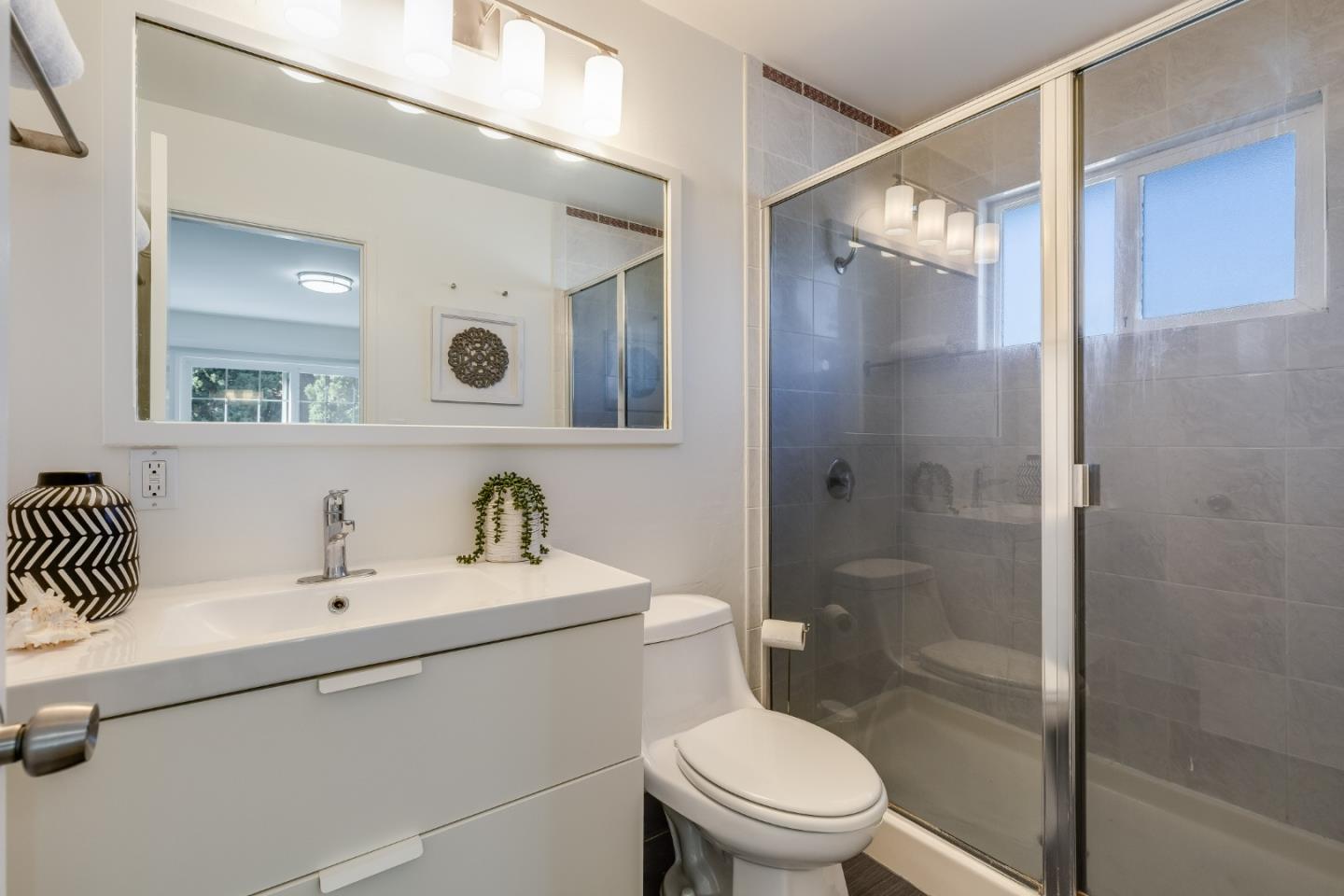 1253 Pomeroy Avenue Santa Clara, CA 95051 - Photo 11 of 17 a bathroom with a sink mirror toilet and shower
