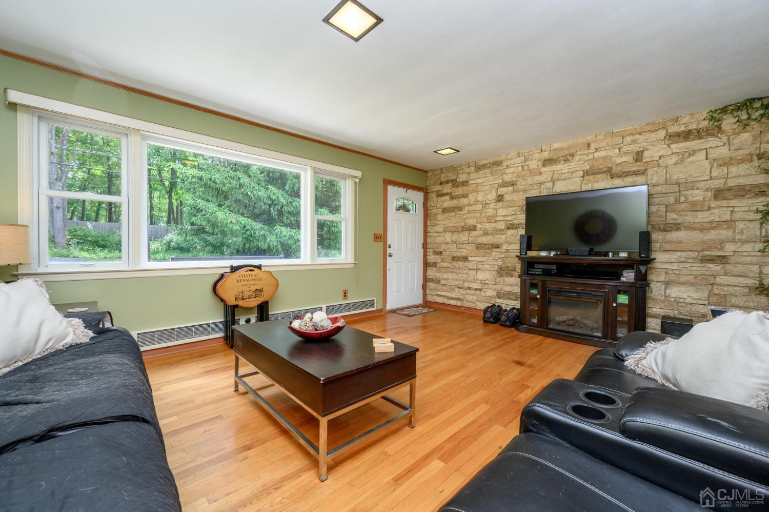 119 Mt Grove Road Califon, NJ 07830 - Photo 7 of 40 a living room with furniture a flat screen tv and floor to ceiling window