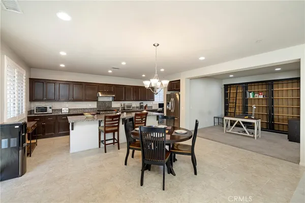 a kitchen with stainless steel appliances kitchen island granite countertop a table and chairs