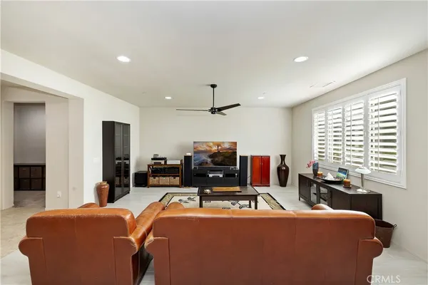 a room with furniture a ceiling fan and a window