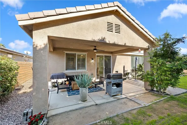 a front view of a house with outdoor seating and a yard