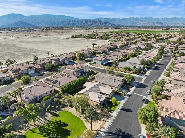 an aerial view of ocean and residential houses with outdoor space