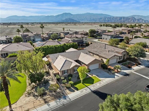 an aerial view of a city with lots of residential buildings and mountain view in back