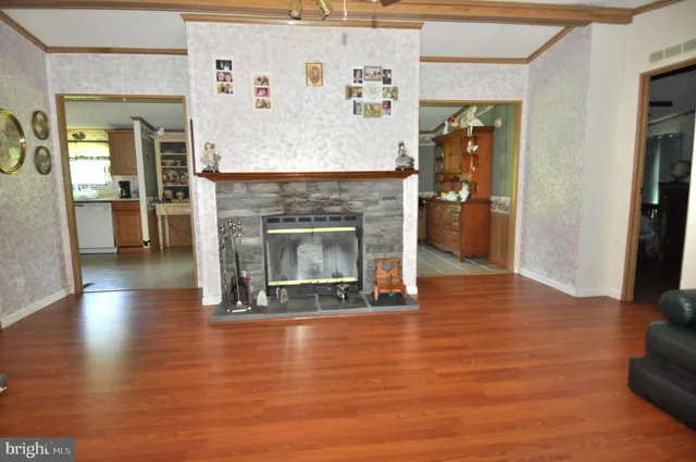 a view of a livingroom with wooden floor and a fireplace