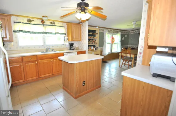 a kitchen with a sink a counter top space and living room area