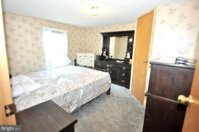 a bedroom with a bed window and dresser