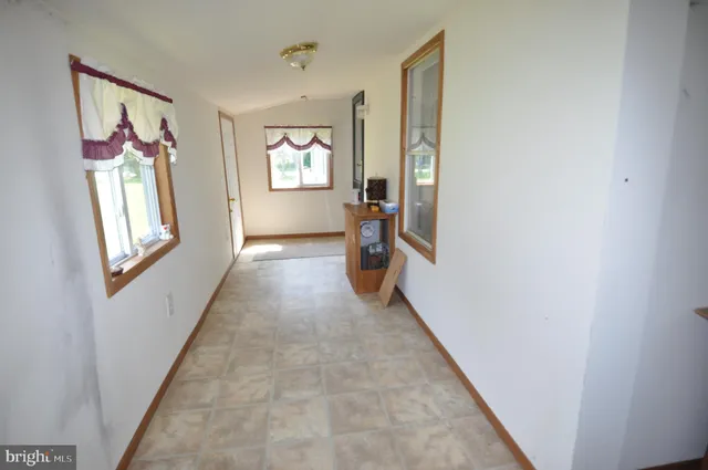 a view of an entryway with wooden floor and a workspace