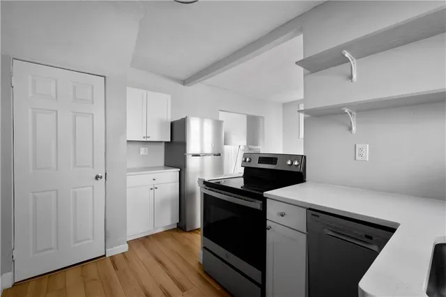 a kitchen with a refrigerator stove and white cabinets