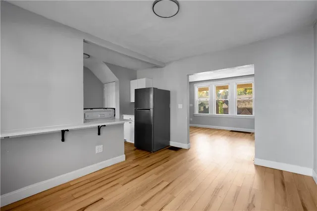 a view of a kitchen with a fridge wooden floor and a window
