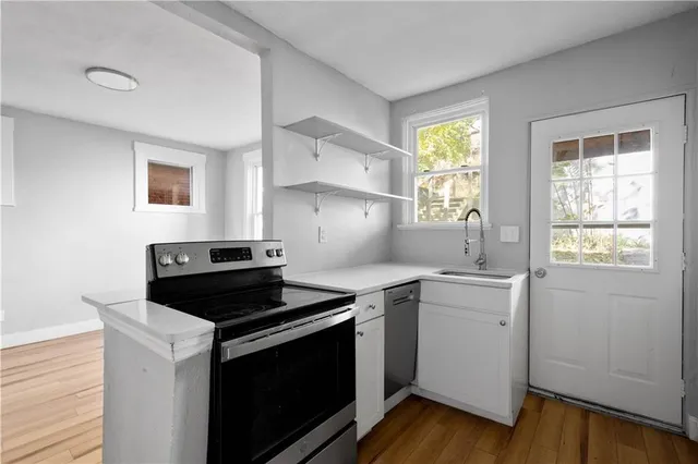 a kitchen with a stove cabinets and wooden floor