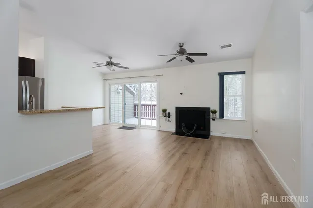 a living room with hard wood floors and a ceiling fan
