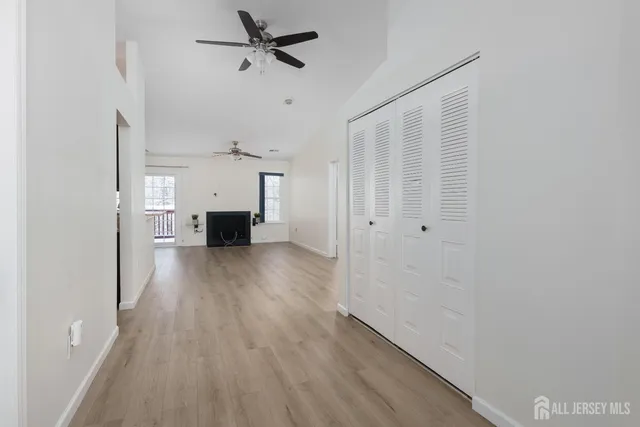 a view of a hallway with wooden floor and a cabinet