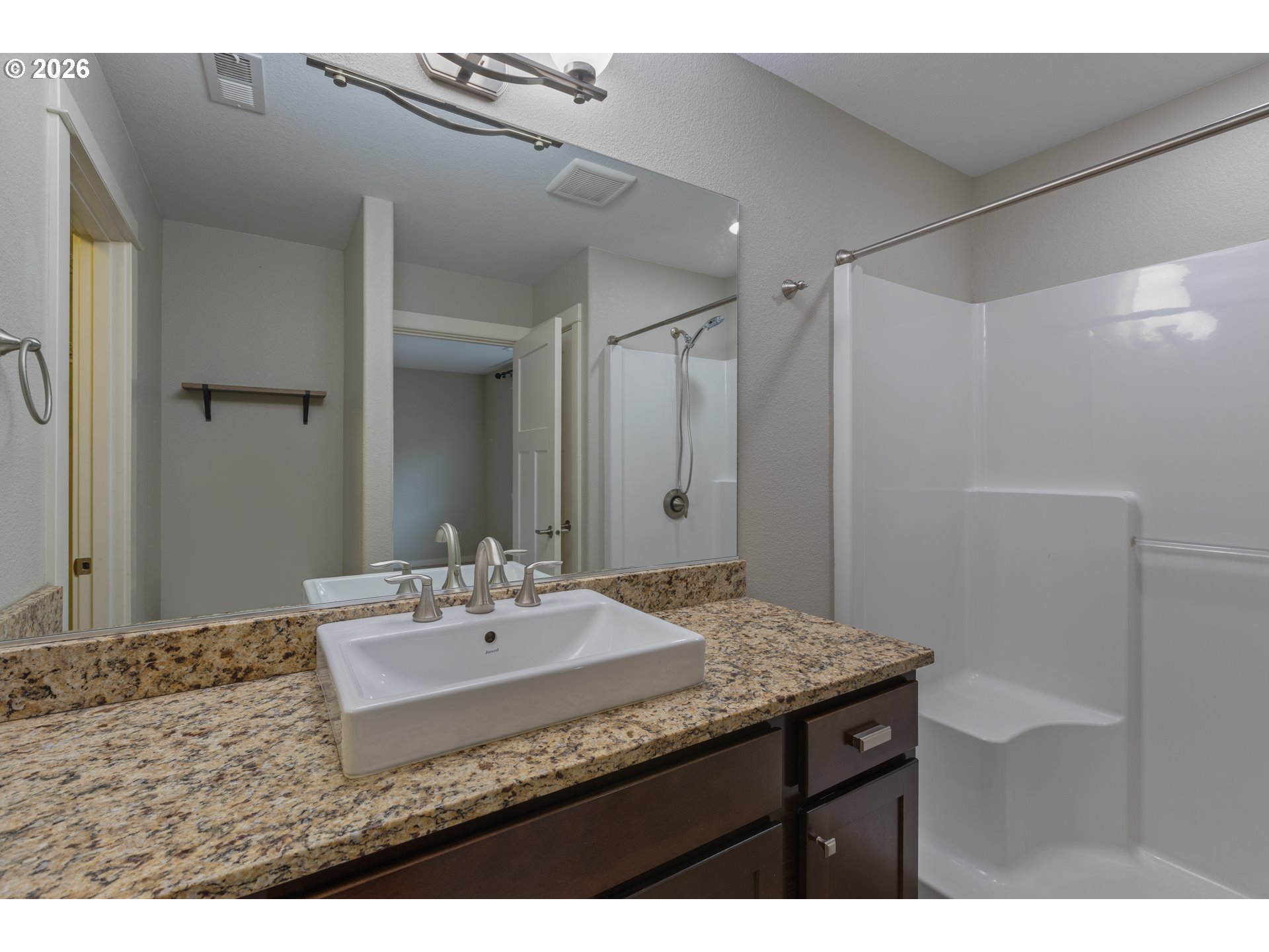 409 South State Street Sutherlin, OR 97479 - Photo 27 of 47 a bathroom with a granite countertop sink a mirror and a shower