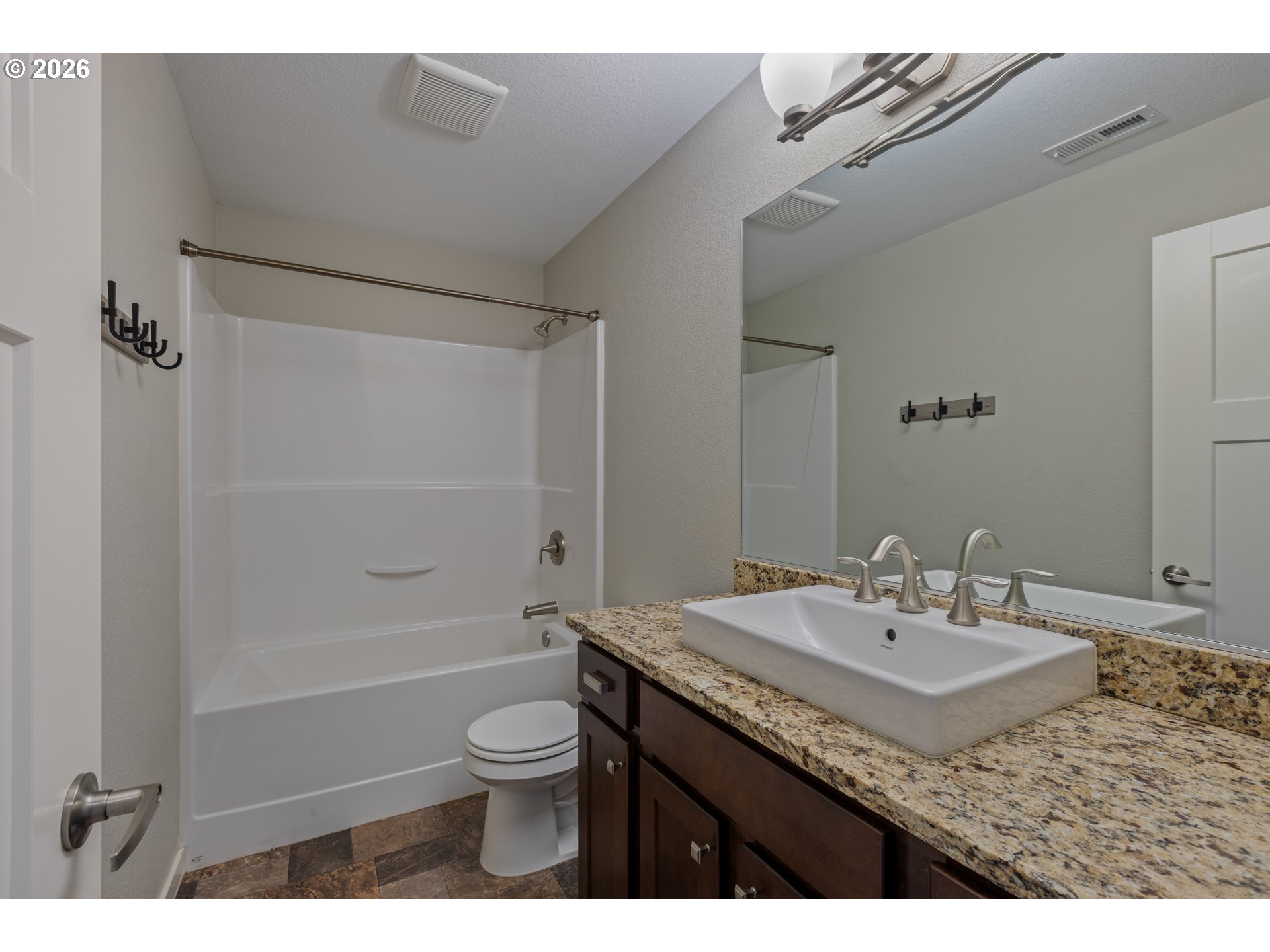 409 South State Street Sutherlin, OR 97479 - Photo 36 of 47 a bathroom with a granite countertop sink a toilet a mirror and shower