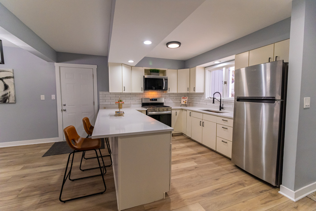 25267 Timber Lane Lake Villa, IL 60046 - Photo 5 of 19 a kitchen with stainless steel appliances a stove a sink a microwave a refrigerator and cabinets