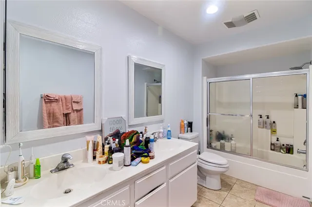a bathroom with a sink mirror vanity toilet and shower