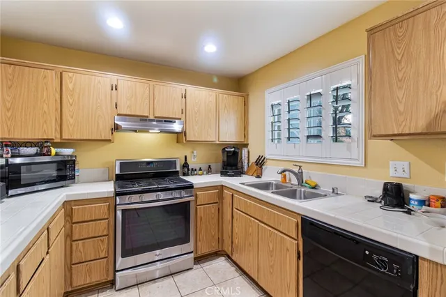 a kitchen with a sink stove top oven and refrigerator