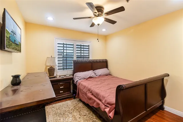 a bedroom with a bed window and a flat screen tv