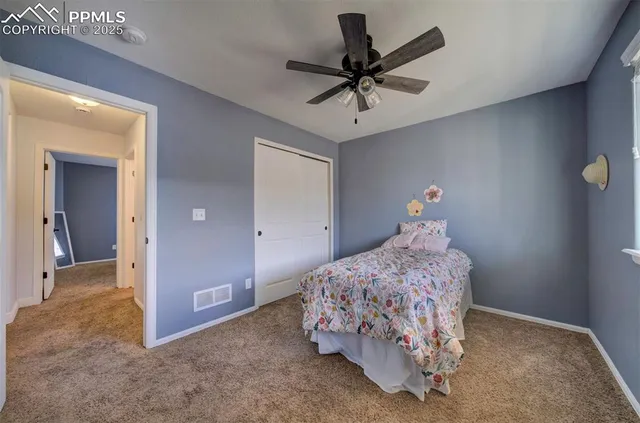 a bedroom with a bed and a ceiling fan