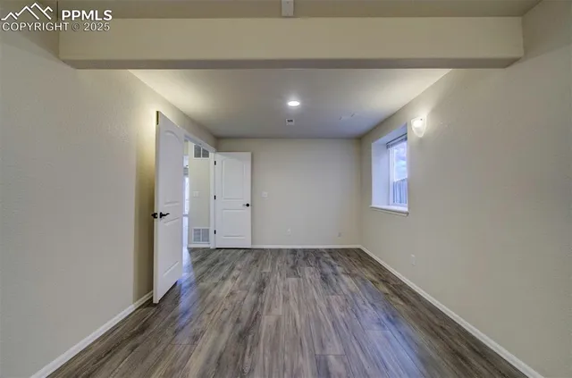 a view of a room with wooden floor and window