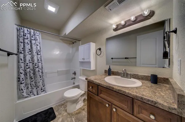 a bathroom with a granite countertop sink toilet a large mirror and shower