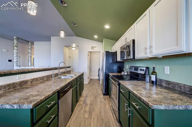 a kitchen with stainless steel appliances granite countertop a stove a sink and a refrigerator
