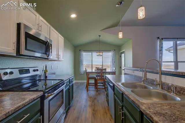 a kitchen with stainless steel appliances granite countertop a sink a stove oven a counter space and cabinets