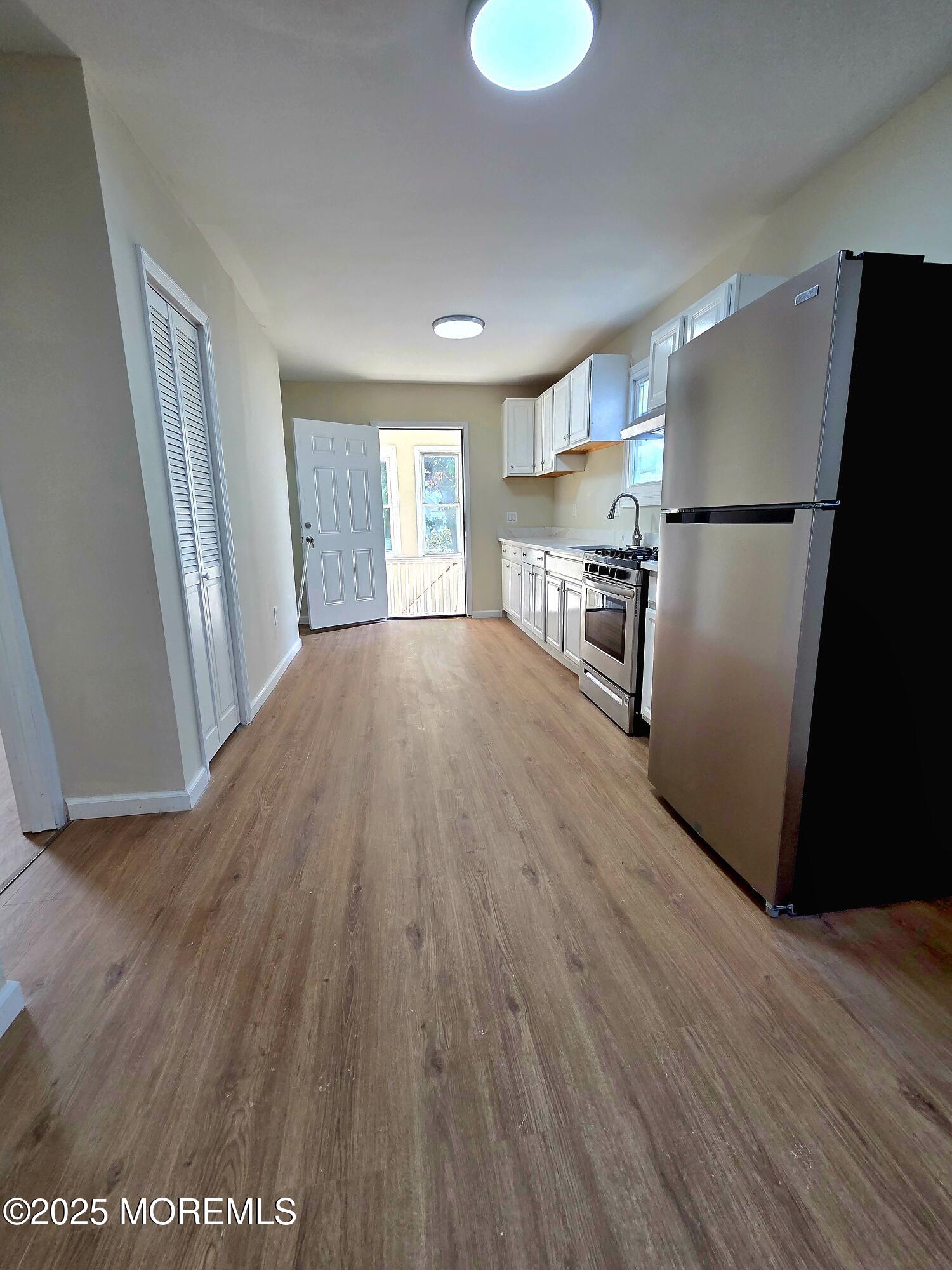216 Delaware Street Elizabeth Port, NJ 07206 - Photo 17 of 40 a view of empty room with wooden floor and window