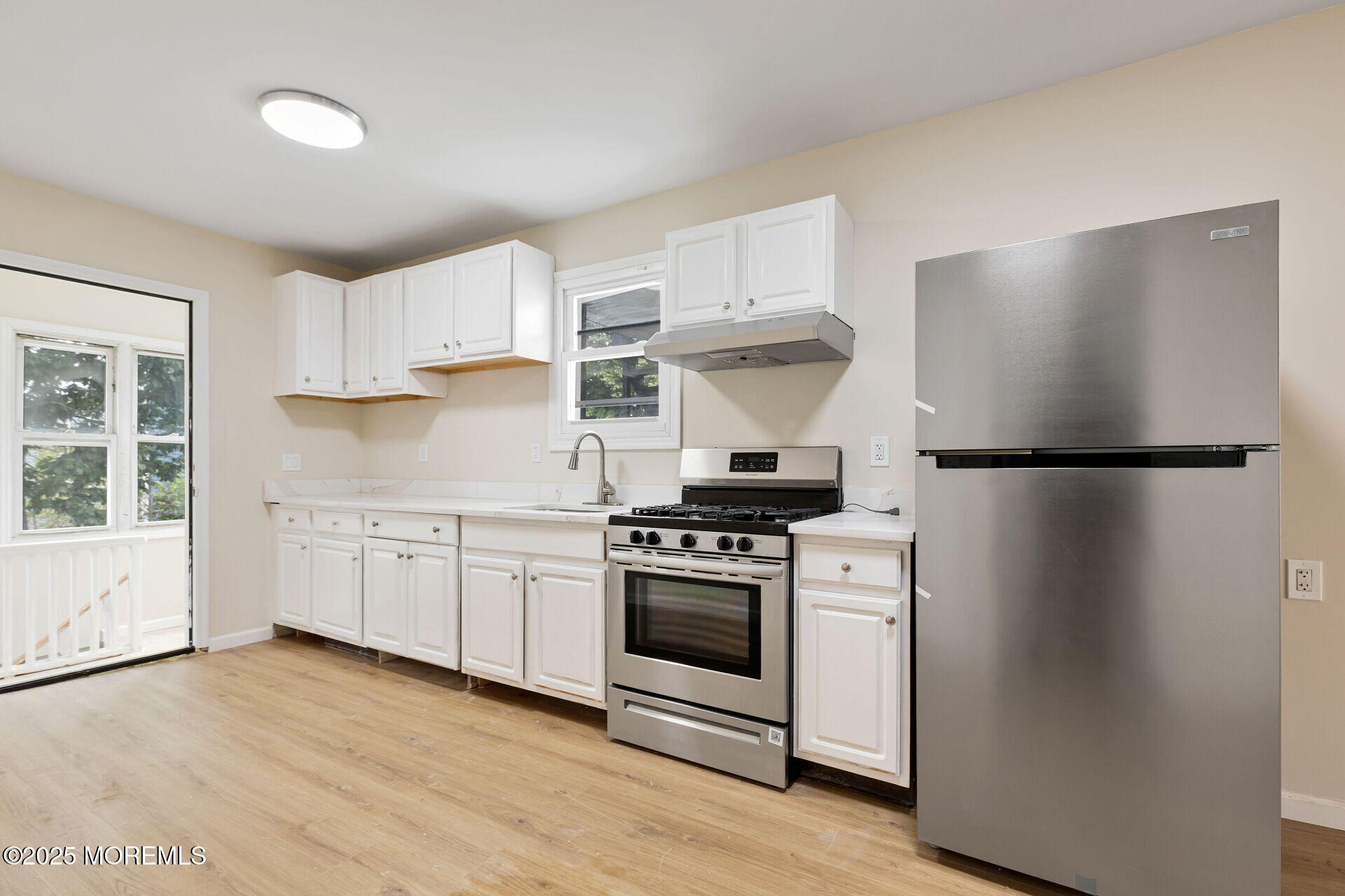 216 Delaware Street Elizabeth Port, NJ 07206 - Photo 18 of 40 a kitchen with a refrigerator stove and white cabinets